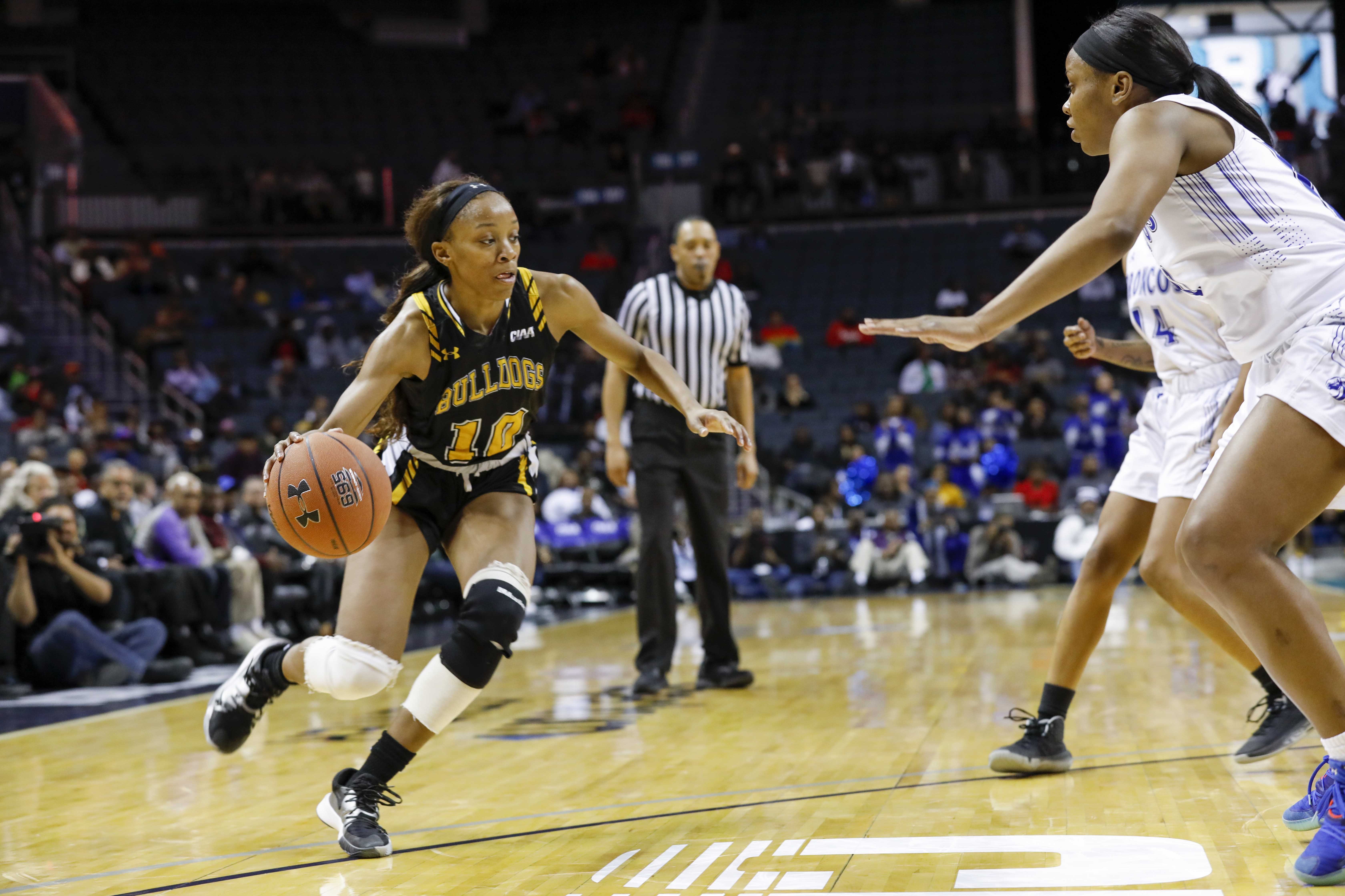 Kyaya Williams fending off a defender on the basketball court