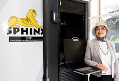 woman standing next to a supercomputer with a yellow sphinx and the word sphinx
